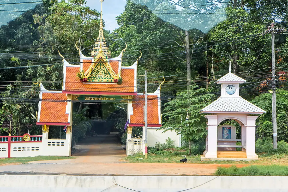 Un portail orné aux tuiles orangées, menant à un complexe de temple à Phuket