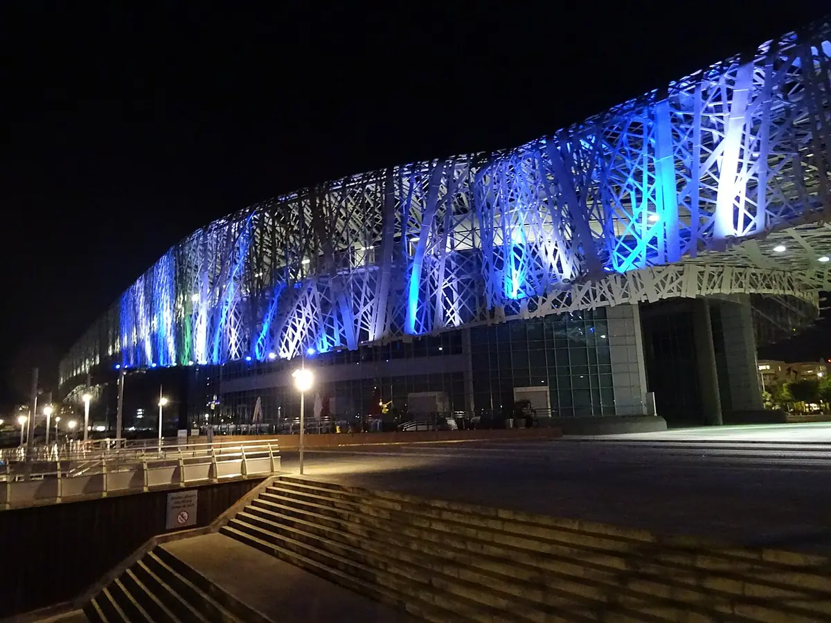 Le Mémorial ACTe illuminé la nuit, sa façade métallique ajourée au bord de l’eau