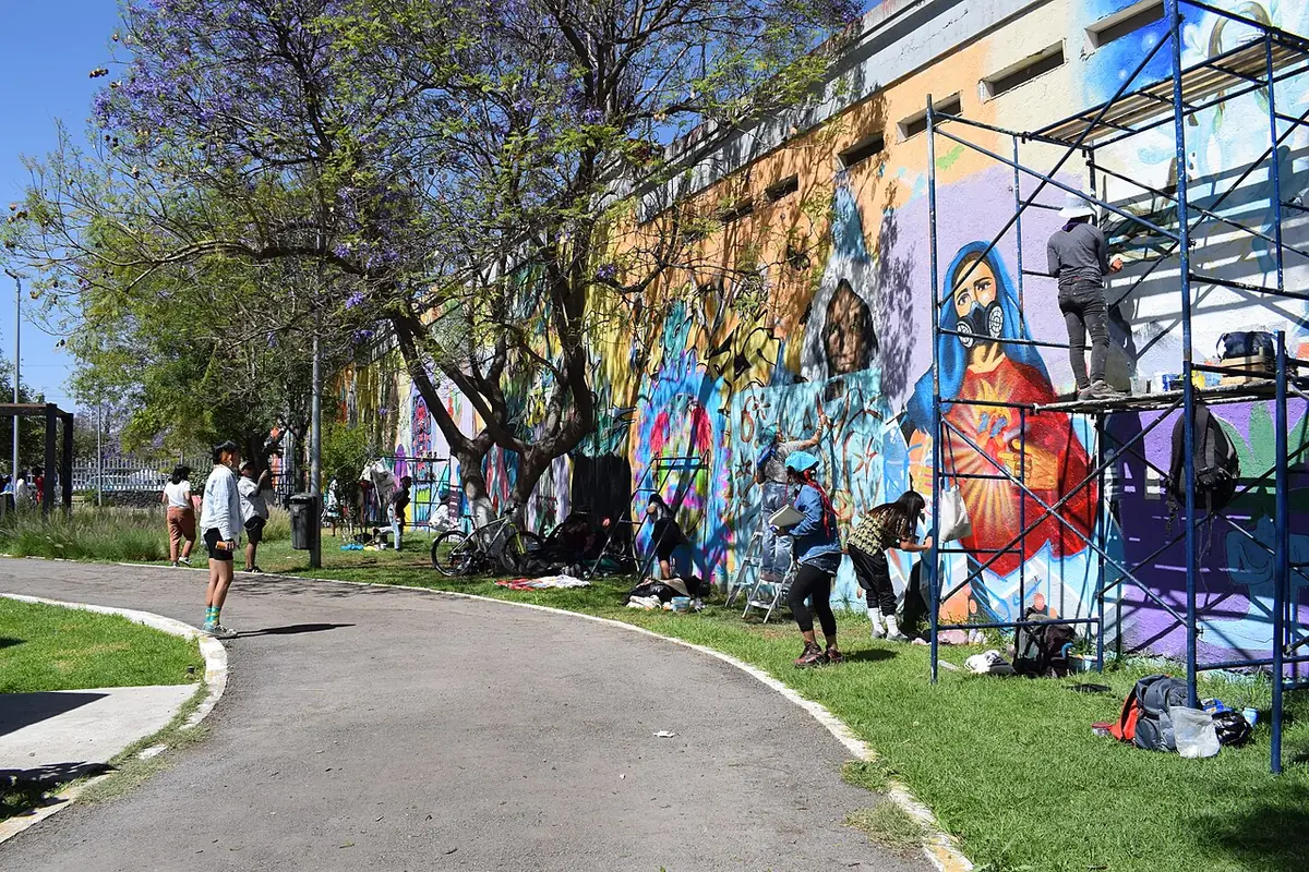 Une allée de parc bordée d’une fresque murale colorée à Querétaro