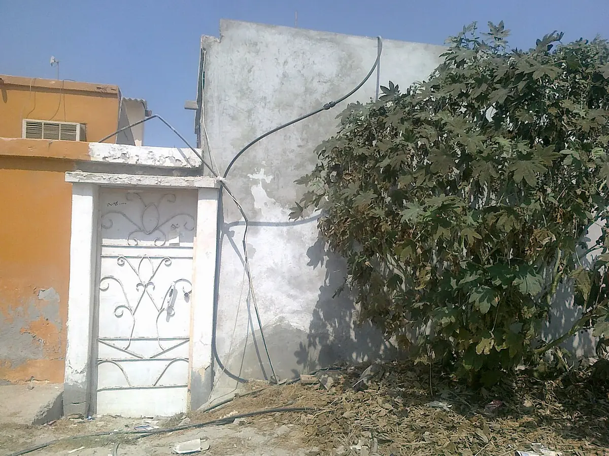Une maison ancienne avec cour clôturée et végétation à Ras Al Khaimah