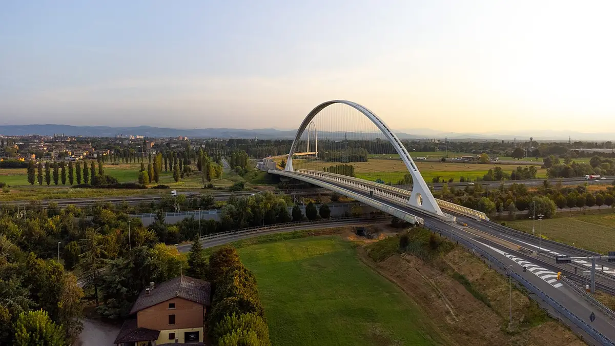 Vue aérienne d’un pont en arc de Calatrava à Reggio d’Émilie, champs et soleil bas à l’horizon