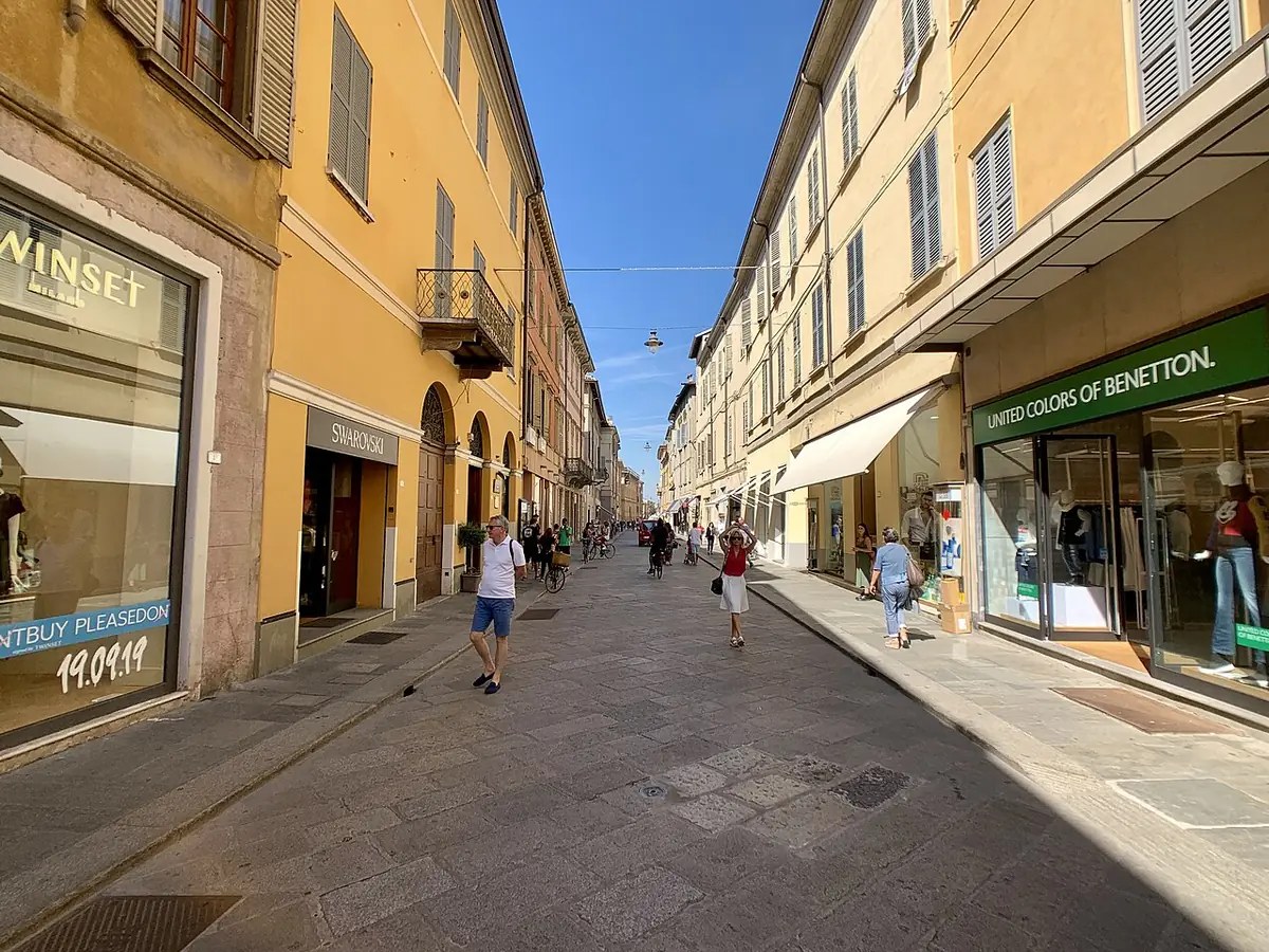 Une rue commerçante du centre de Reggio d’Émilie, bordée de façades ocre