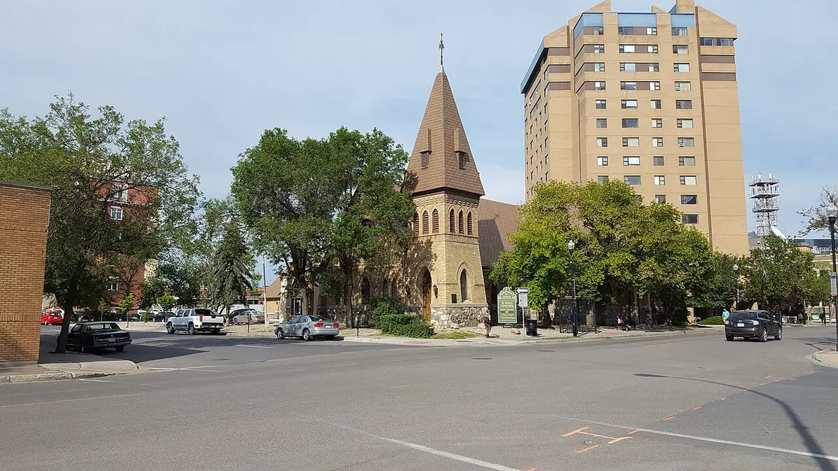 La cathédrale St. Paul de Regina à un carrefour arboré, une tour d’habitation derrière