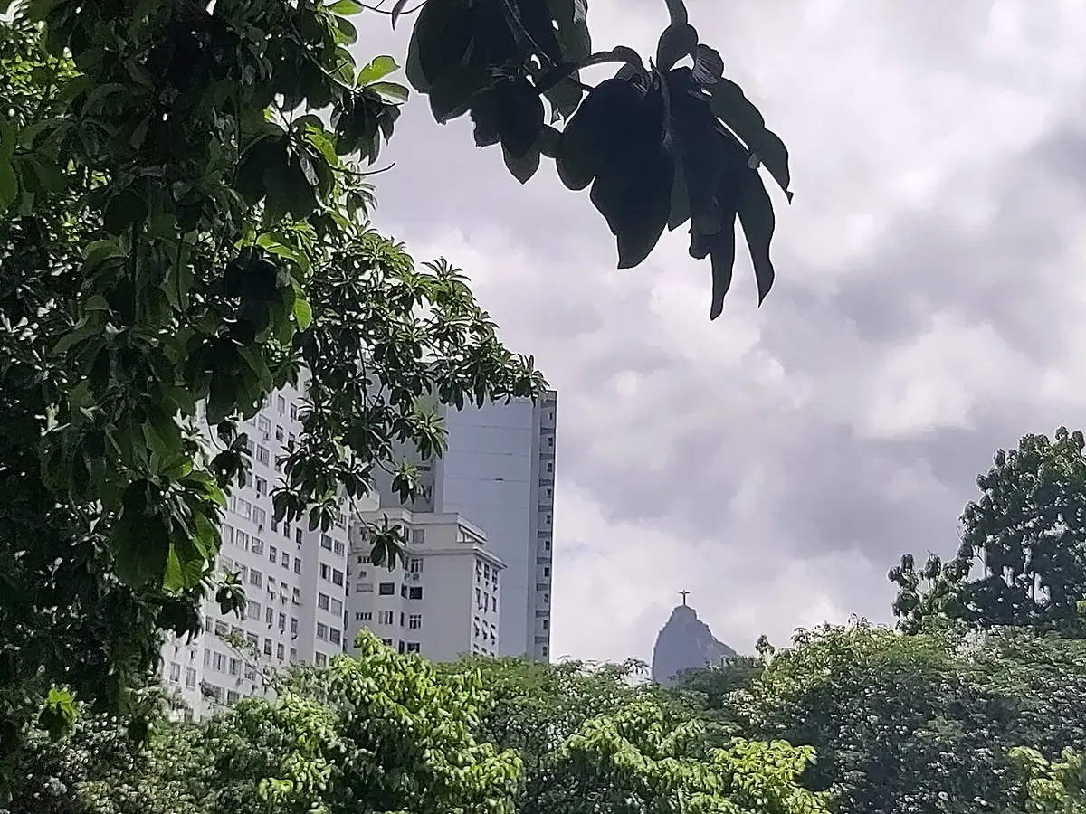 Un immeuble de Rio sous un ciel nuageux, le Christ Rédempteur au loin