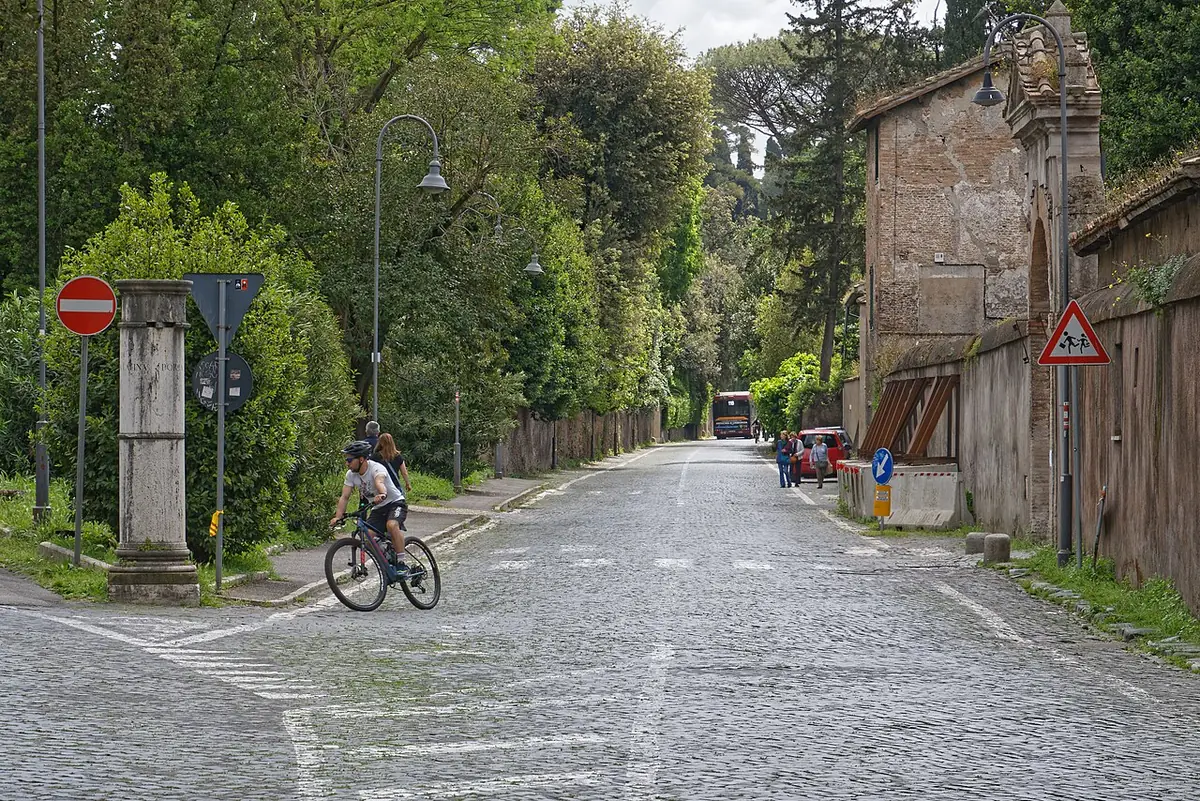 Rue pavée bordée d’arbres et de vieux murs près du parc des Scipions à Rome
