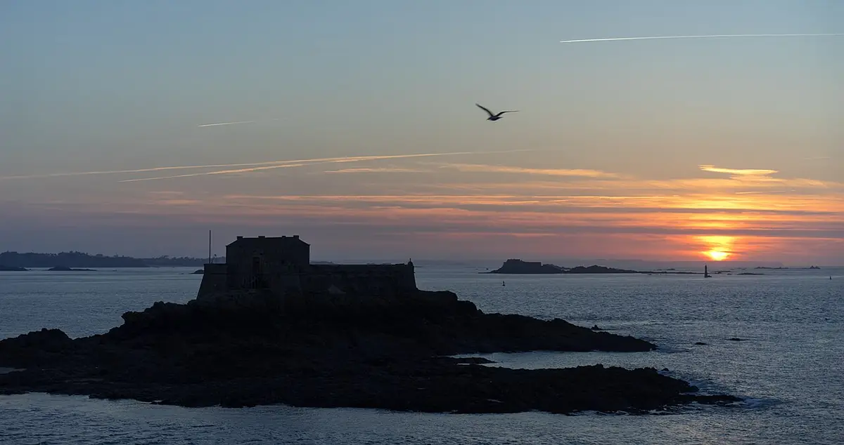 Le fort du Petit Bé en silhouette sur la mer au coucher du soleil