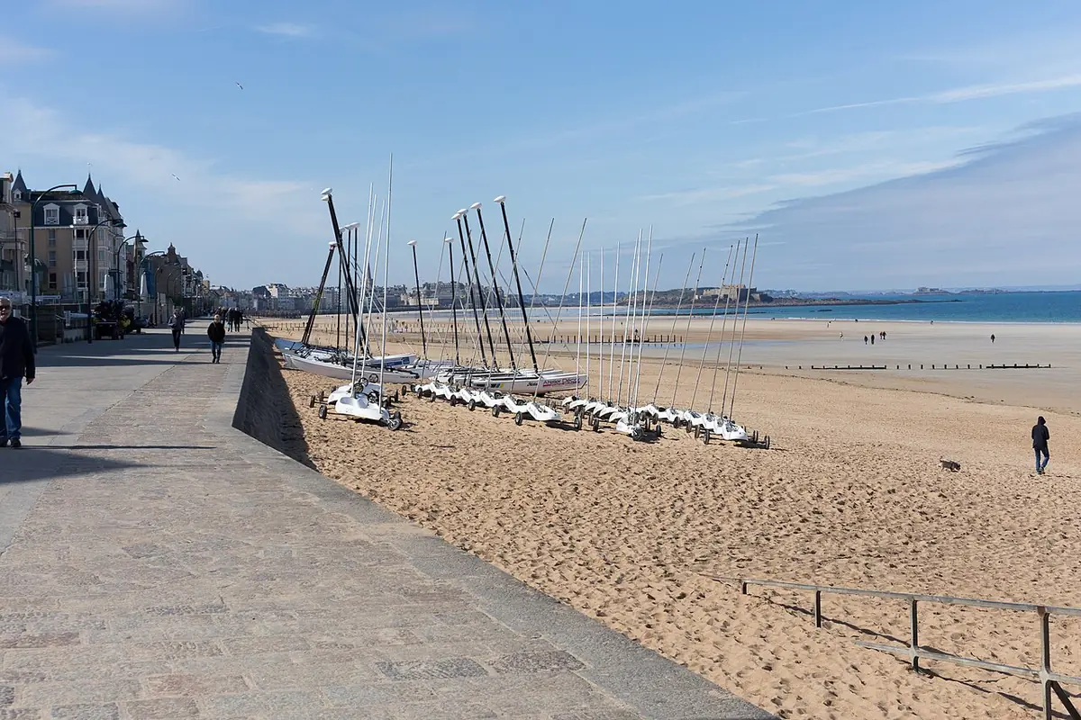 Catamarans sur le sable de la plage de la Hoguette, promenade et immeubles à gauche