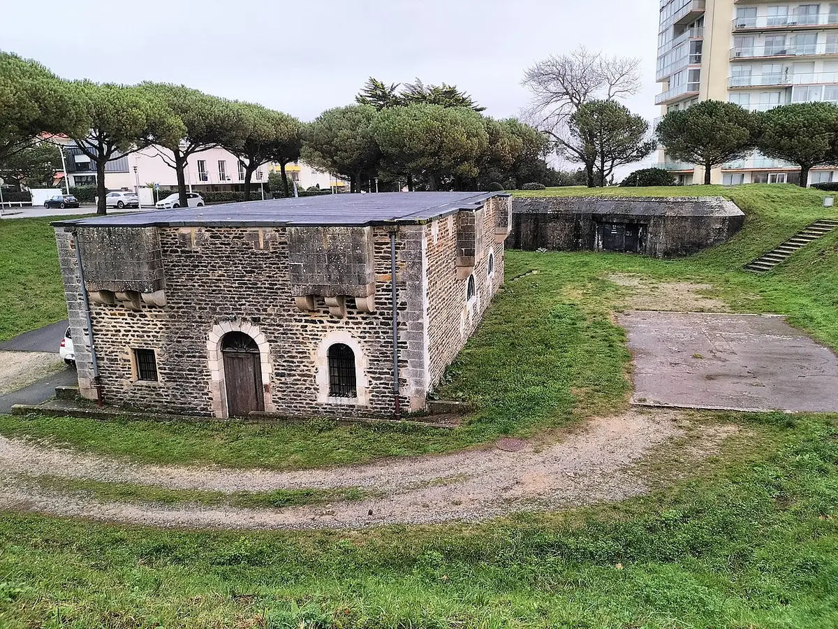 Le fort Villès en pierre dans un parc, une tour d’habitation en arrière-plan