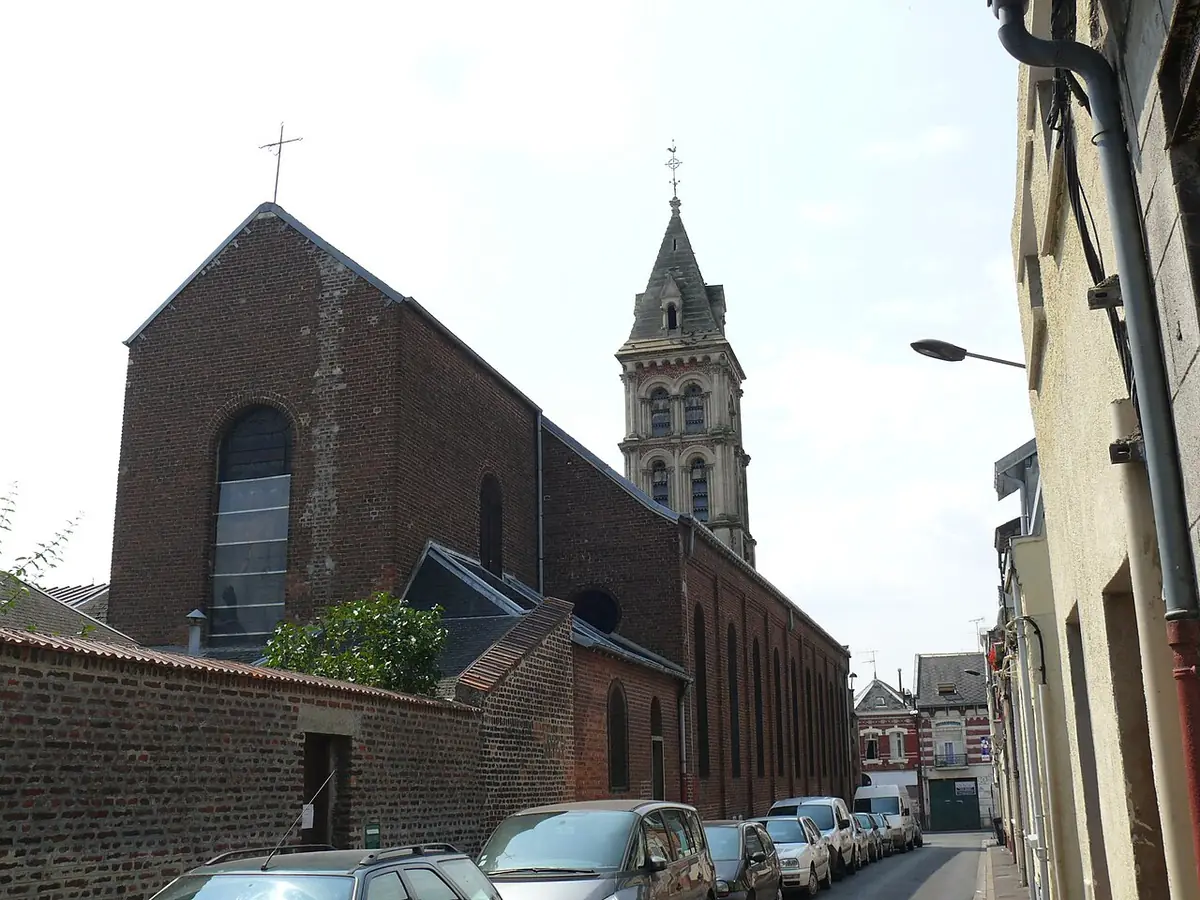 Rue de Saint-Quentin avec l’église Saint-Jean en brique et des maisons alignées