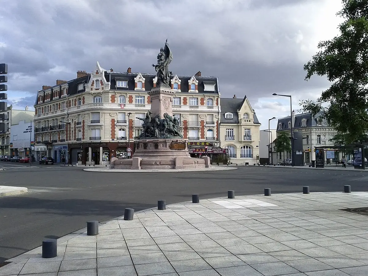 Place de Saint-Quentin avec un monument sculpté et de grands immeubles à balcons