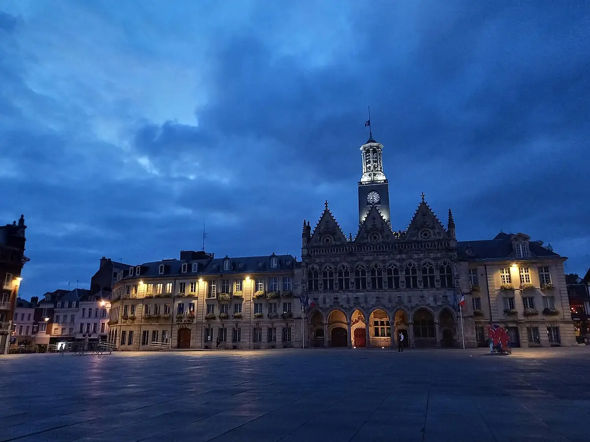 L’hôtel de ville de Saint-Quentin illuminé sur la place de l’Hôtel-de-Ville à la tombée de la nuit