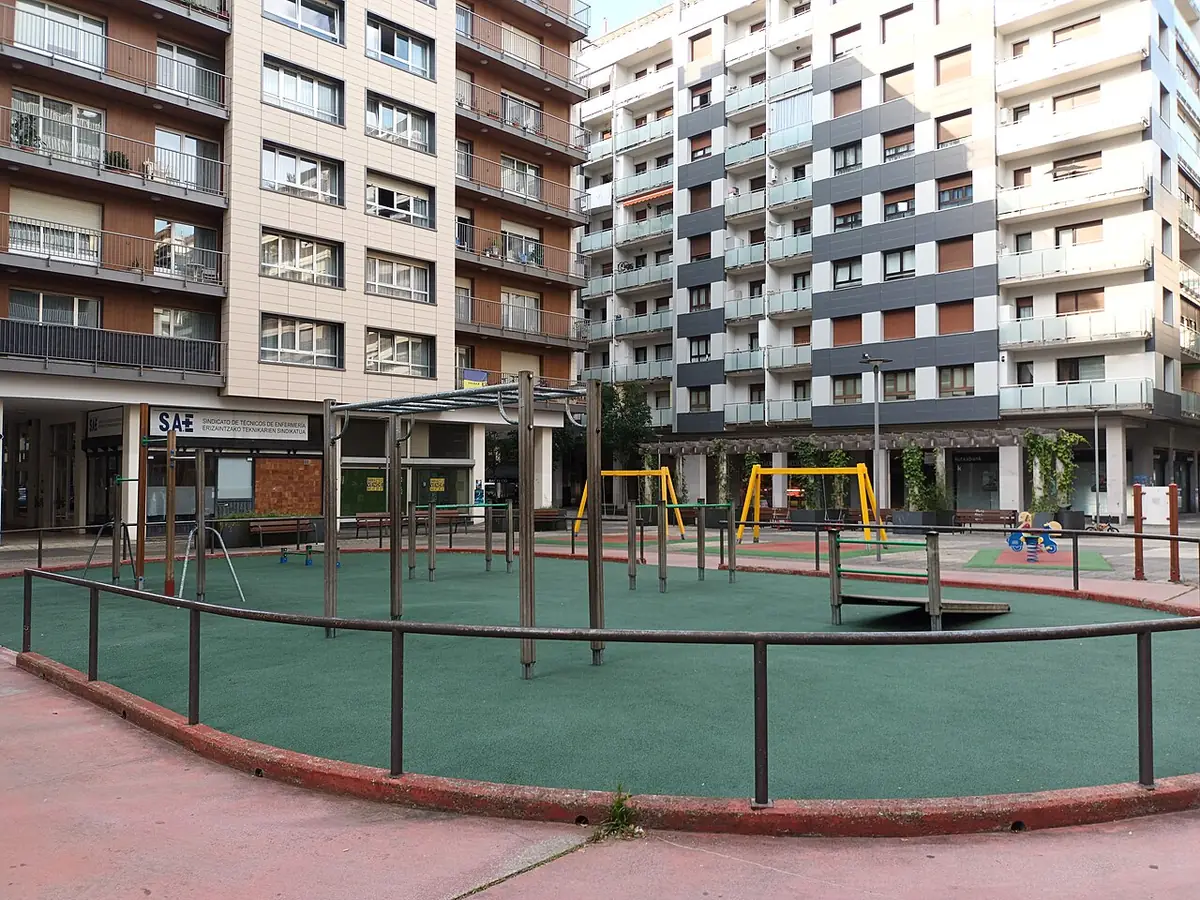 Aire de jeux et agrès en plein air entourés d’immeubles d’habitation à Saint-Sébastien