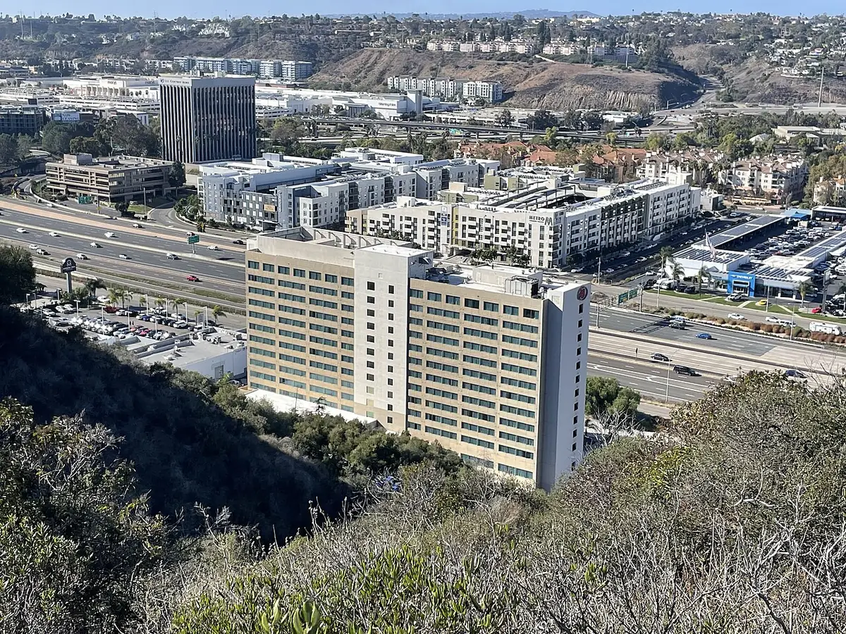 Une vue aérienne de Mission Valley à San Diego, immeubles en hauteur près de l’autoroute et des collines