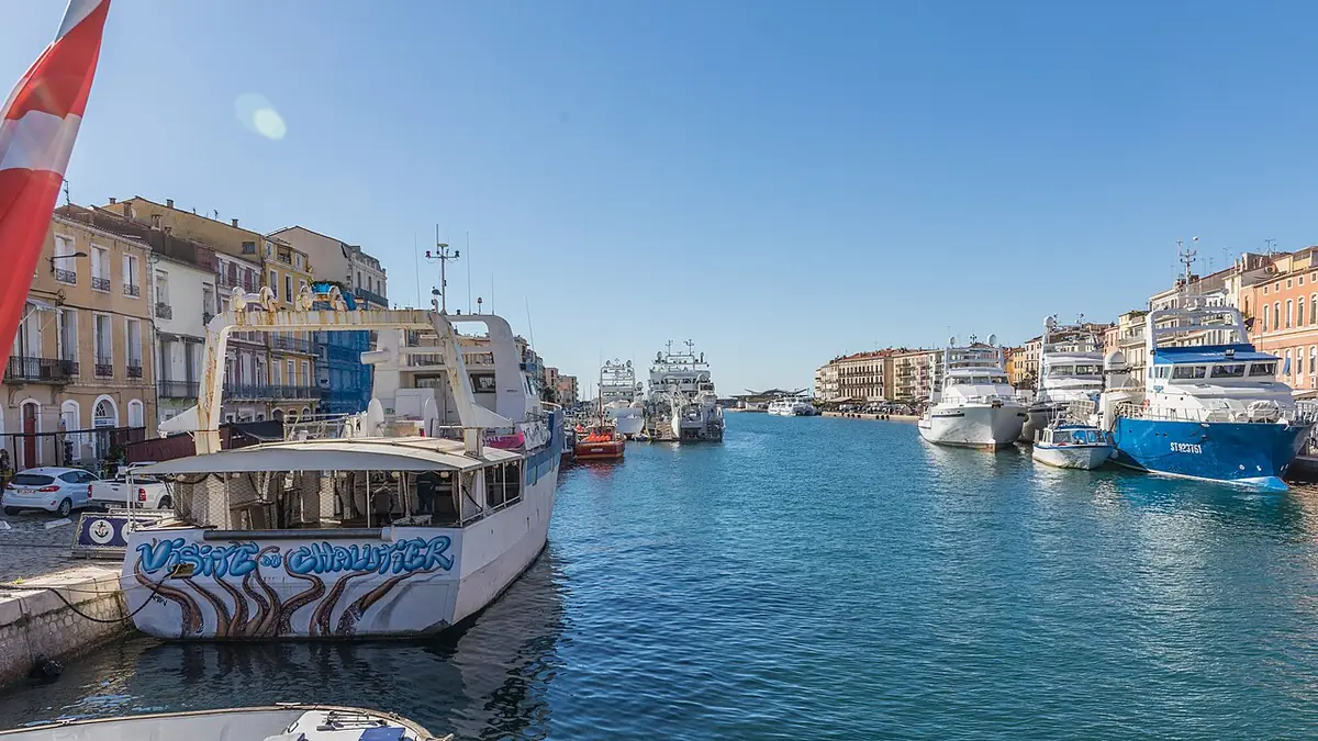 Le port de pêche de Sète, bateaux amarrés le long des quais sous un ciel bleu