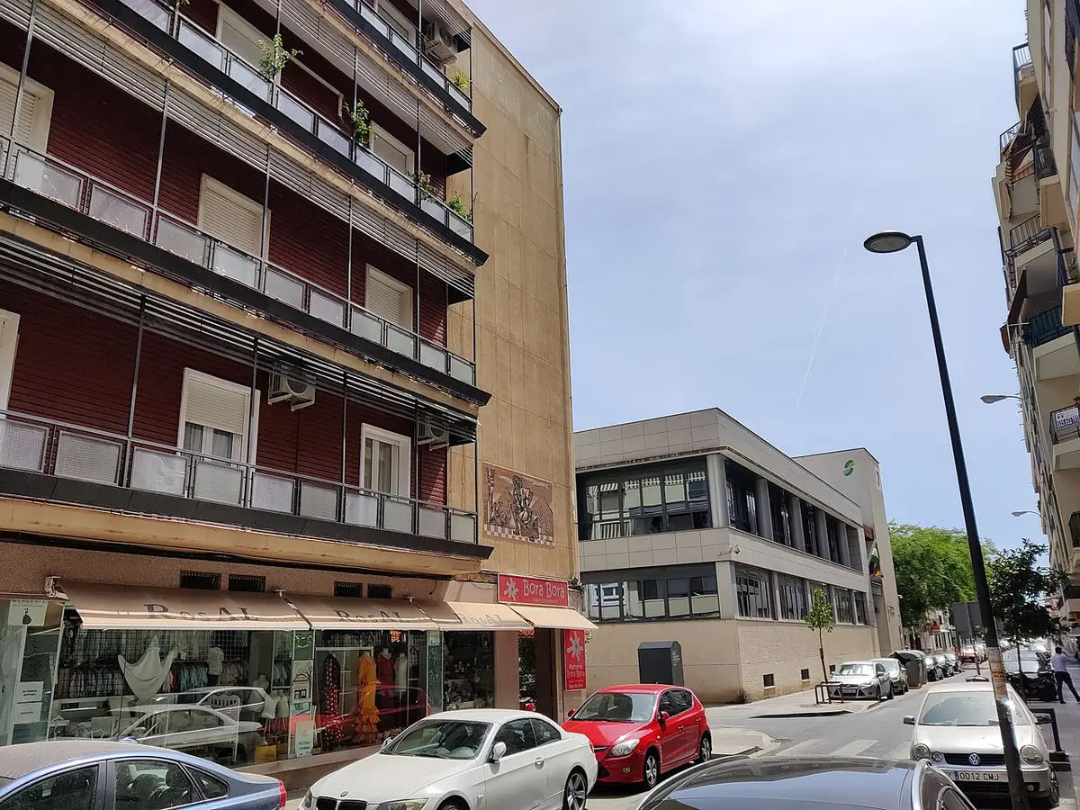 Rue de Séville bordée d’immeubles d’habitation à balcons, voitures garées le long du trottoir