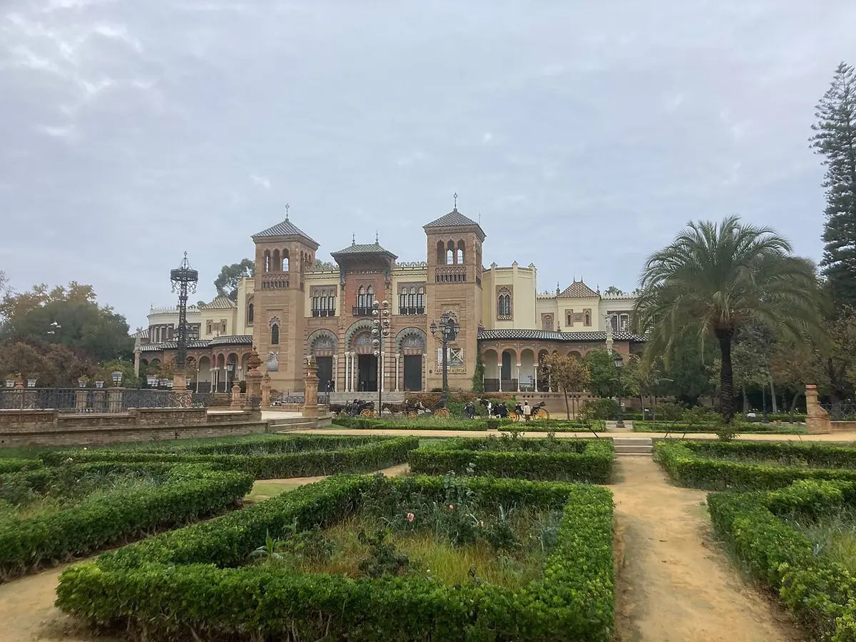 Les jardins de la plaza de América, haies taillées et palmiers devant un pavillon ancien