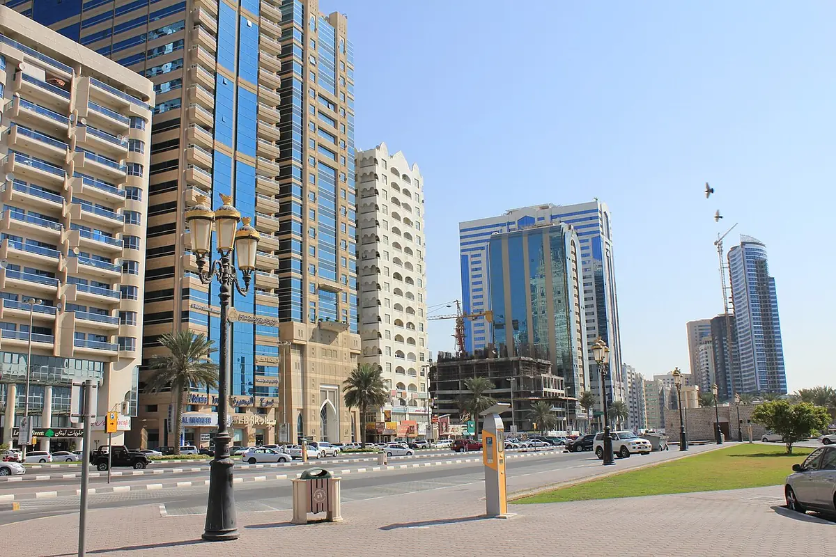 Une avenue de Sharjah bordée de tours et de lampadaires décoratifs
