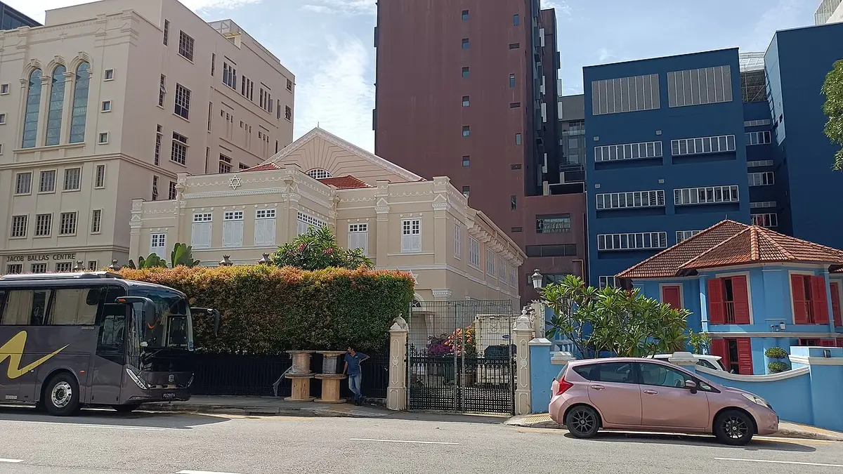 Un angle de rue à Singapour où une rangée de shophouses côtoie des tours modernes