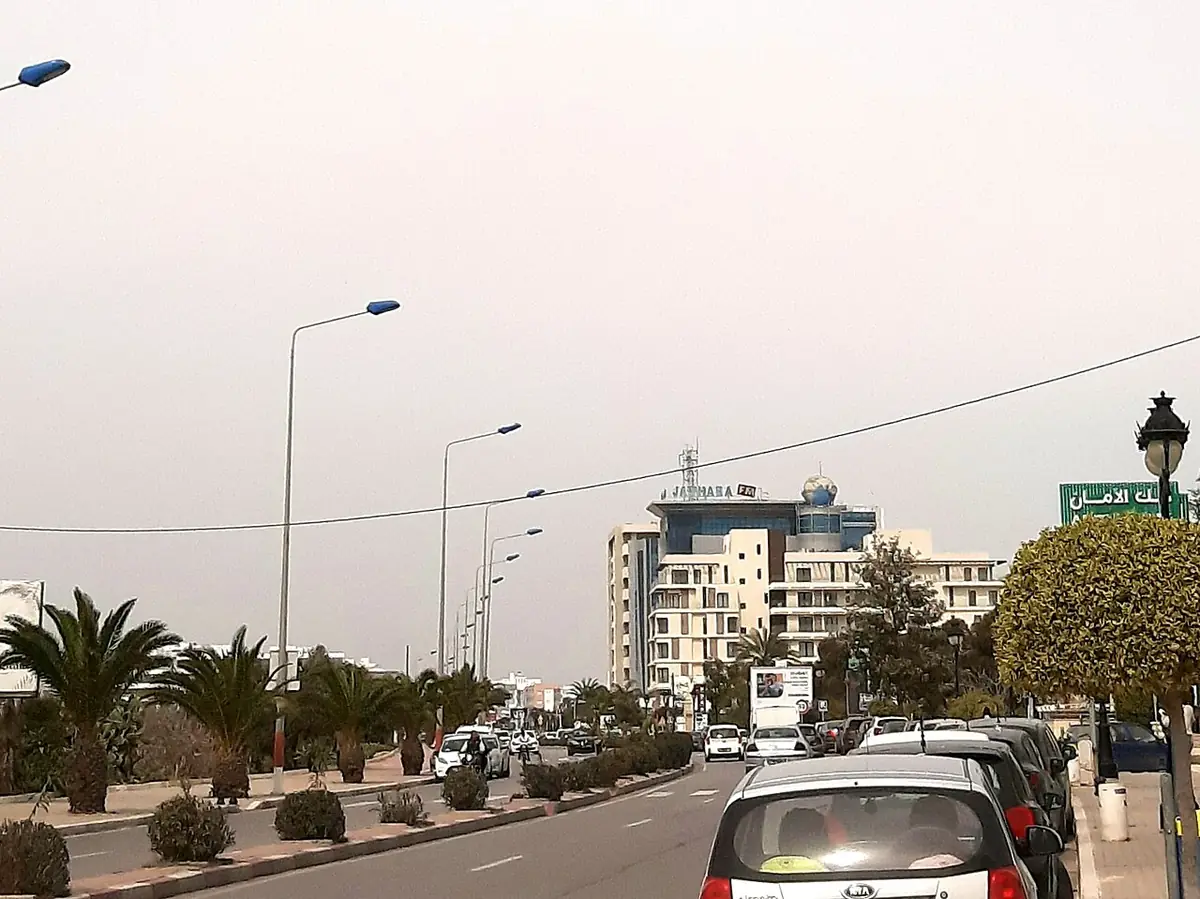 Une avenue bordée de palmiers et d’immeubles sur la route du 14 Janvier à Sousse