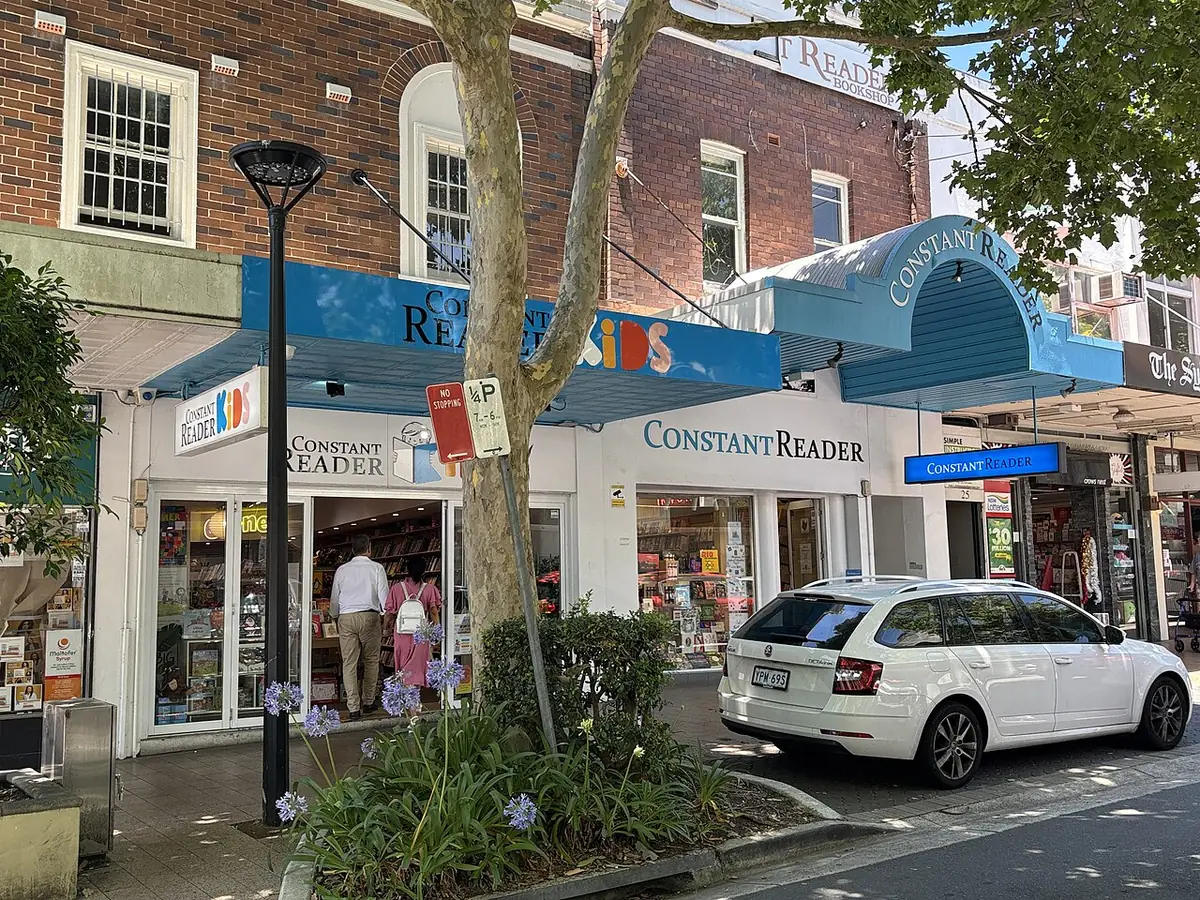 Une rangée d'auvents de boutiques et une librairie le long d'une rue ensoleillée de Sydney