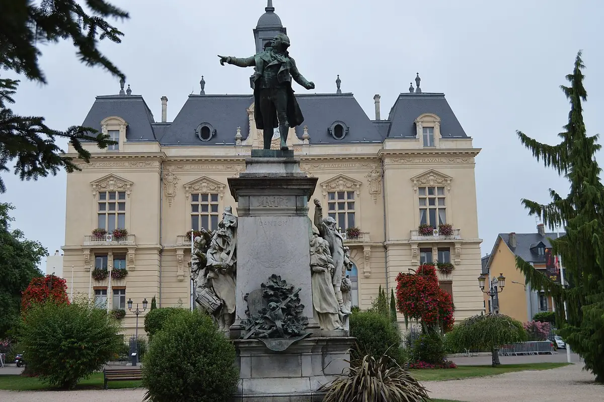 L’hôtel de ville de Tarbes, une statue sur un haut socle devant sa façade et des massifs fleuris