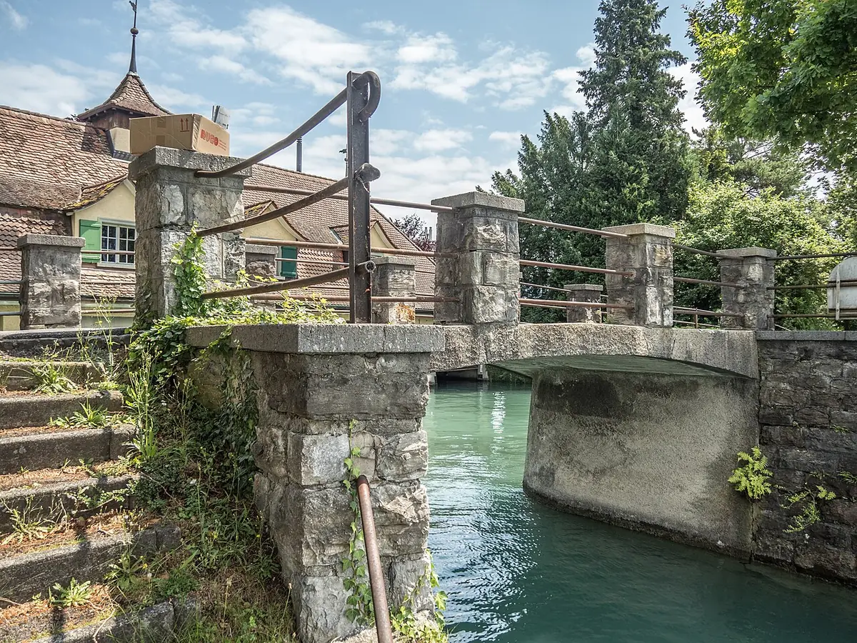 Un pont piéton en pierre traversant un bras de l’Aar à Thoune