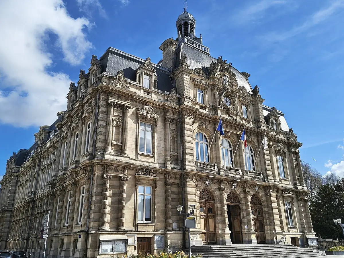 La façade richement sculptée d’un grand édifice du centre de Tourcoing, sous un ciel bleu