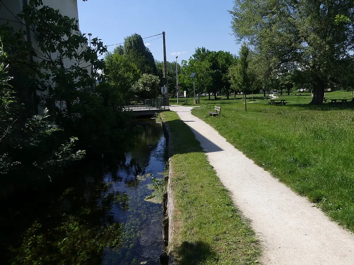 Un chemin longe le canal de la Grande Marquise dans le parc arboré de Châteauvert à Valence