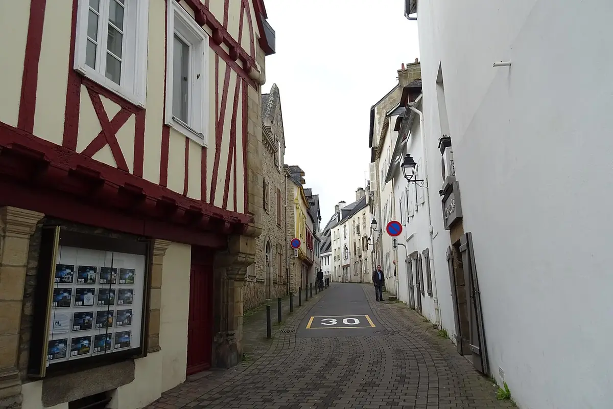 La rue des Tribunaux à Vannes, étroite et pavée, entre une maison à pans de bois et des façades blanches