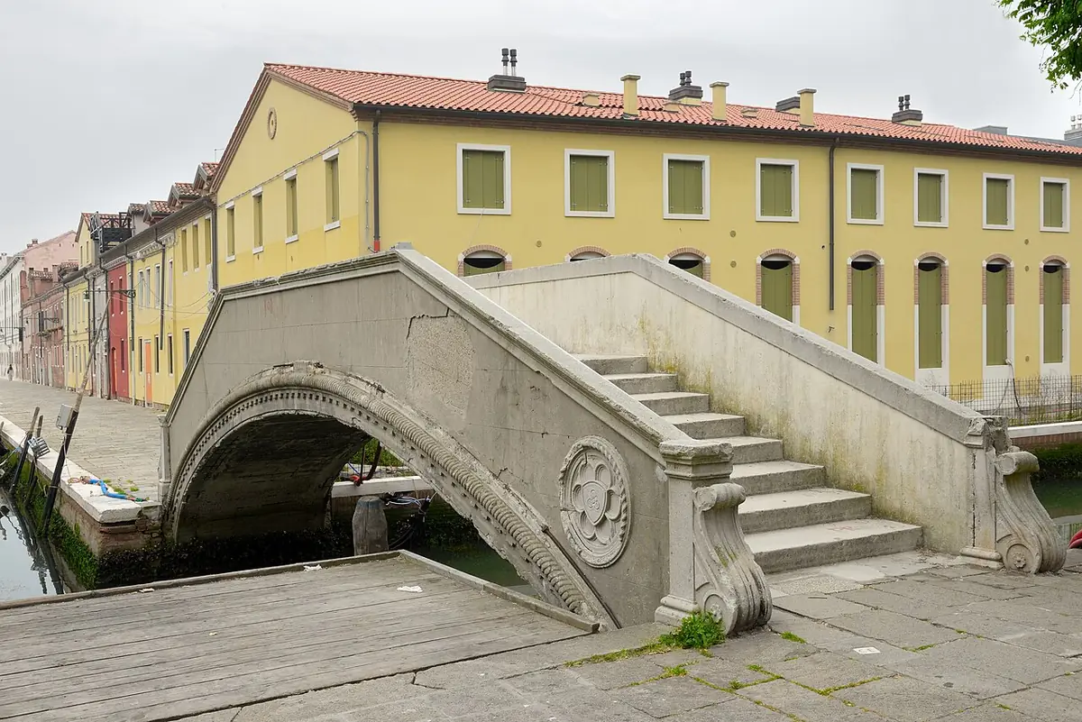 Le pont Priuli en pierre sur un canal de la Giudecca, devant une maison jaune