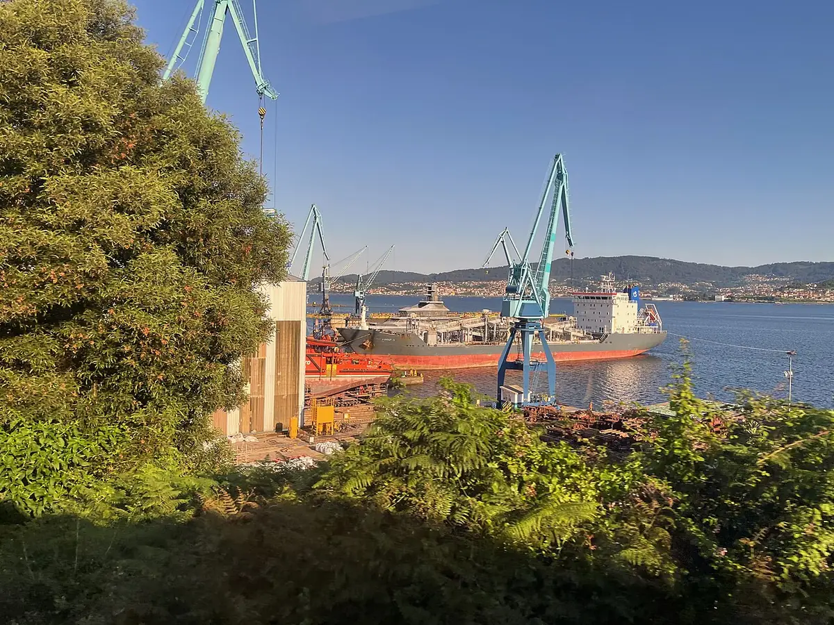 Les chantiers navals de Vigo vus depuis la rive, grues et cargo au loin