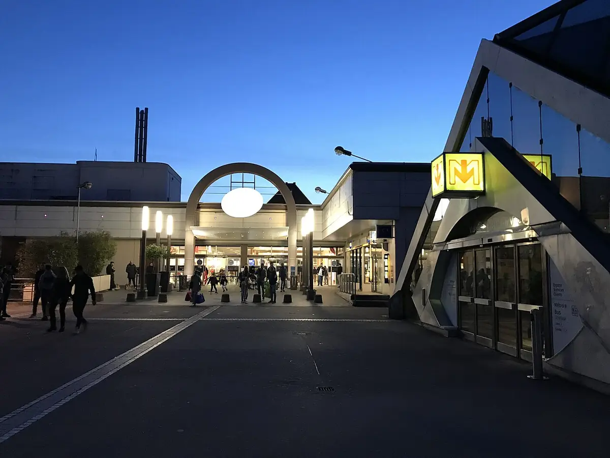 Entrée éclairée du centre commercial V2 à Villeneuve-d’Ascq en fin de journée