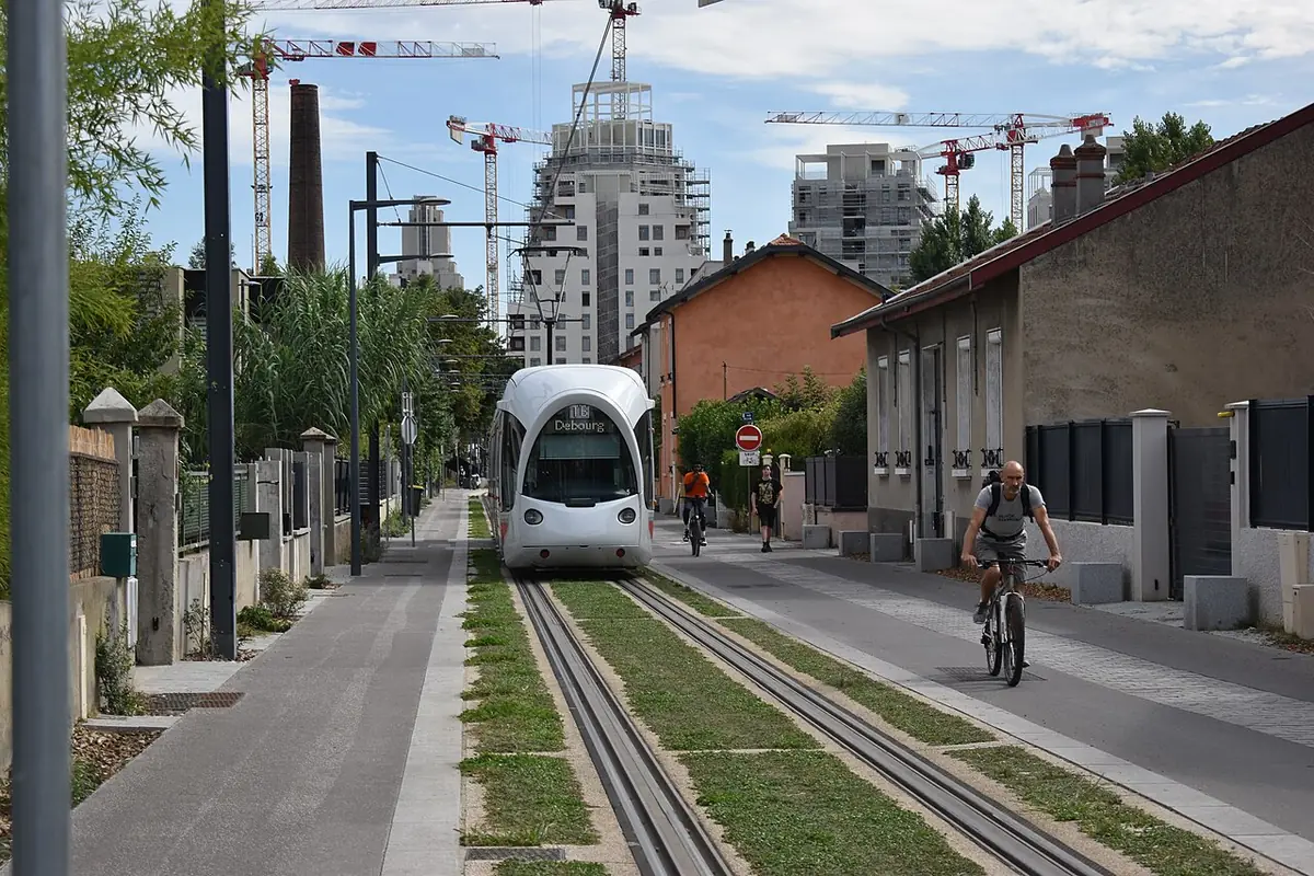 Le tramway T6 circulant dans une rue de Villeurbanne bordée d’immeubles