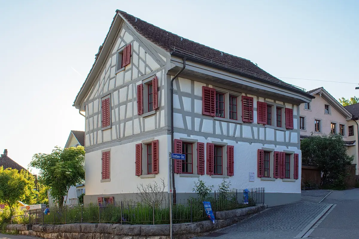Une maison à colombages avec volets rouges à l’angle d’une rue de Winterthour